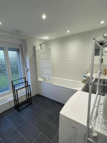 a white bathroom with a tub and a sink at Gîte Le Lyséas 6 personnes proche Forêt de Mormal & Animaux bienvenus in Bousies