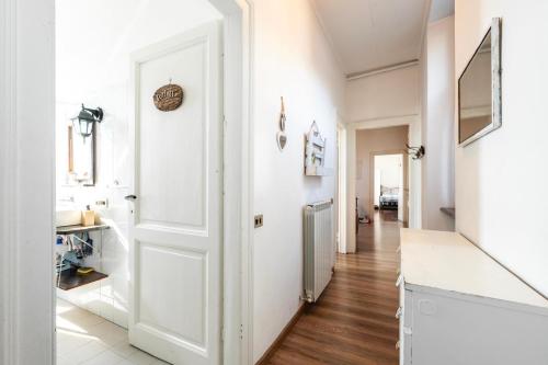 a hallway with a white door and wooden floors at Casa Clem centro Menaggio con possibilità di garage in Menaggio