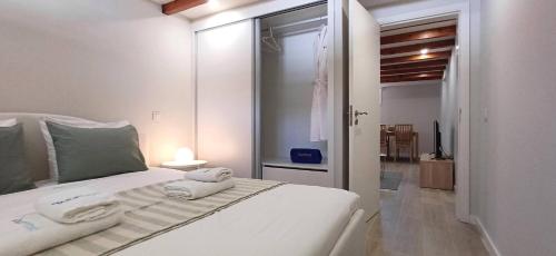 a bedroom with a white bed with towels on it at 1000Jo Apartment T2 in Gulpilhares