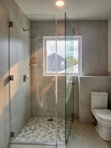 a bathroom with a glass shower with a toilet at Luxurious Loft on Spinnaker! in Knysna
