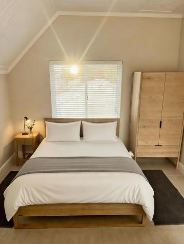 a bedroom with a large bed and a window at Luxurious Loft on Spinnaker! in Knysna