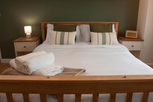 a bedroom with a bed with white sheets and pillows at The Halfway Inn in Morden
