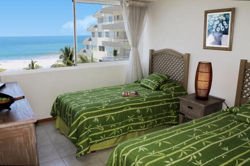 2 camas en una habitación con vistas al océano en Quintas del Mar II, en Los Cerritos