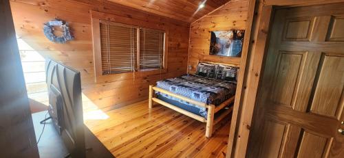 a bedroom in a log cabin with a bed in it at The Bears Den in Gatlinburg