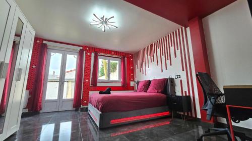 a red bedroom with a bed and a window at La Suite Rouge Proche Paris & Stade De France in Drancy