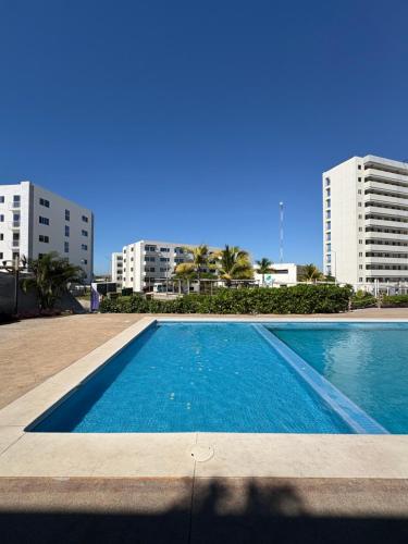 a swimming pool in front of two tall buildings at Fantástico Depa en BLUU con PLAYA ARTIFICIAL - Turquesa 208 - in Mazatlán