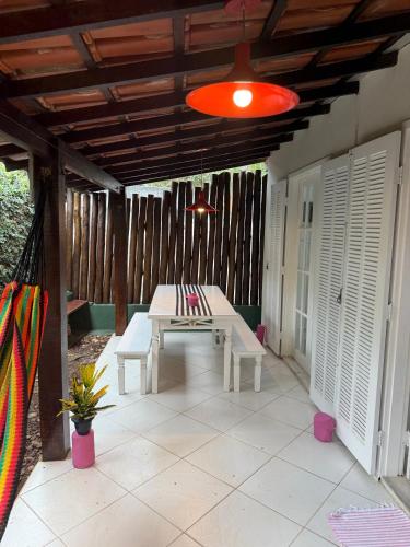 a patio with a white table and a red light at Casa Praiana Búzios in Búzios