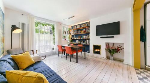 a living room with a blue couch and a table at Designer Flat in Bethnal Green in London