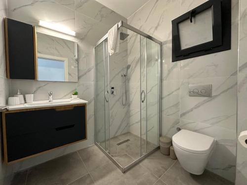 a bathroom with a shower and a toilet and a sink at Caesar Resort Atilius in Trikomo