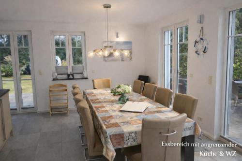 a dining room with a table and chairs at Villa Mara - für 12 Gäste, Sauna, 1 Wirlwanne, 2 Duschen, Kamin, 5 SZ, 3 WC, Highspeed Internet, abgezeuntes Grundstück in Glowe