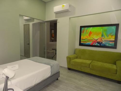 a bedroom with a bed and a green couch at Panorama 1947 - Hotel Boutique Galería in El Banco