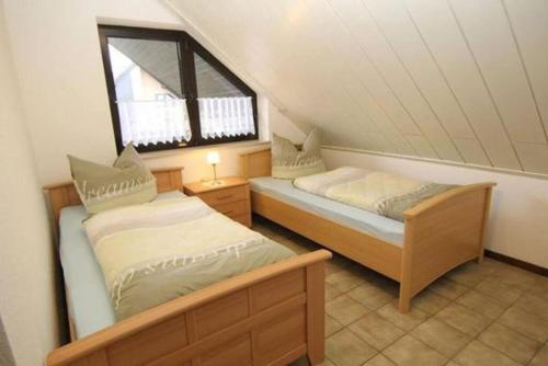 a attic bedroom with two beds and a window at Oberhausener Ferienwohnung in Oberhausen