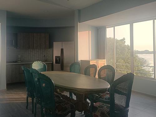 a dining room with a table and chairs and a kitchen at Panorama 1947 - Hotel Boutique Galería in El Banco
