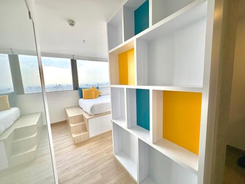 a small room with a bed and a shower at Happa Hub Hotel in Bogotá