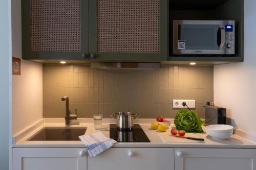 a kitchen with a sink and a counter with vegetables on it at HUB Apartments St Georg in Hamburg