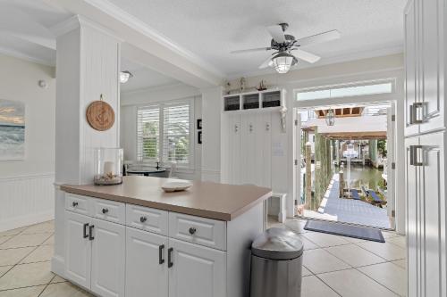 a kitchen with white cabinets and a ceiling fan at Harbor On Holiday Isle in Destin