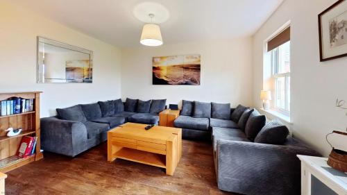 a living room with a couch and a table at Coral Shores - Part of the The Bay Filey Holiday Village with pool, gym and direct beach access, pub, restaurant, tennis and meadows walks in Filey