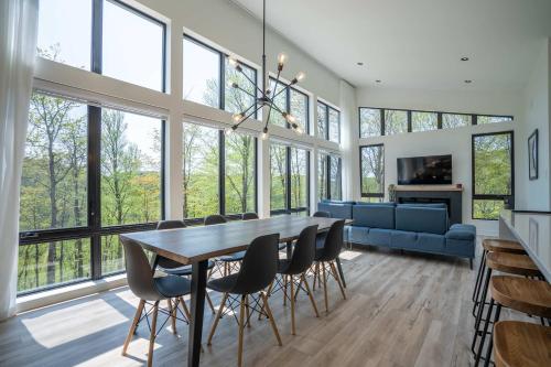 a large dining room with a table and chairs at Chalet du Golf avec Spa in Saint-Faustin