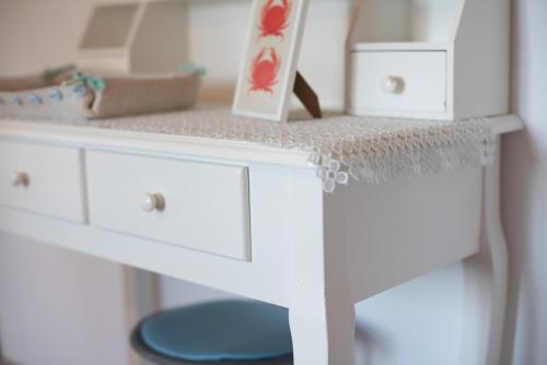 a white desk with two drawers and a table with a dollstrationstration at AZZURRO LIDO ADRIANO VISTA MARE in Lido Adriano