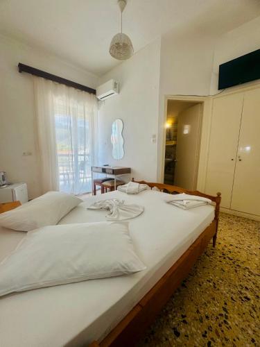 a large white bed in a room with a window at Asteria in Katastárion