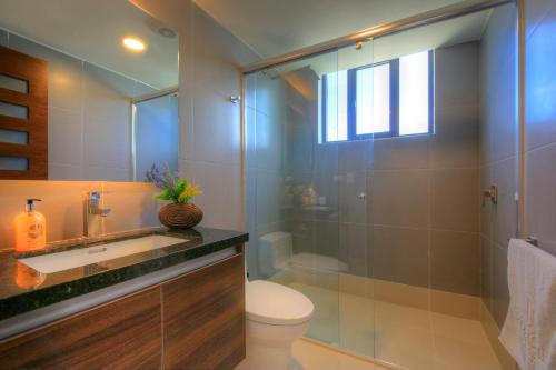 ein Badezimmer mit Dusche, Toilette und Waschbecken in der Unterkunft Lujoso Dpto vista a ciudad Edificio Poseidón in Manta
