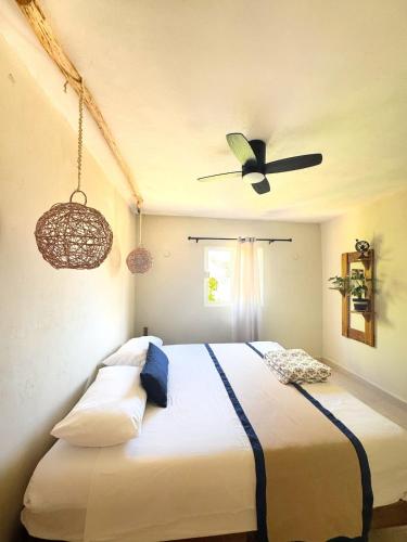 a bedroom with a bed with a ceiling fan at Casa Roca II in Isla Mujeres
