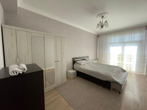 a bedroom with a bed and a desk and a window at Caspian Mirvari in Sumqayıt