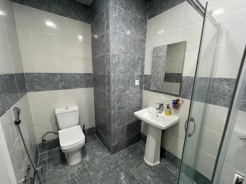 a bathroom with a toilet and a sink and a shower at Caspian Mirvari in Sumqayıt