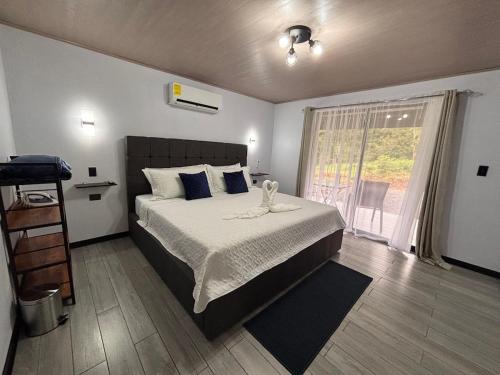 a bedroom with a bed and a large window at Harmony Home La Fortuna in Fortuna