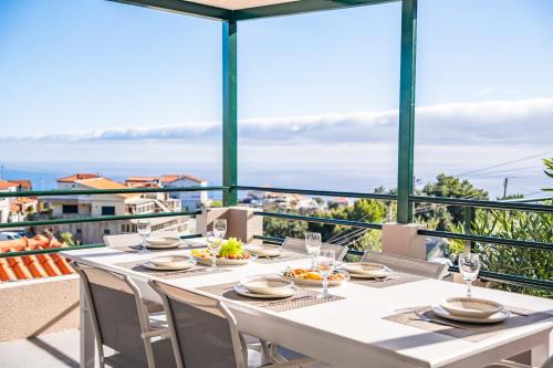 a dining room with a table and chairs and the ocean at Johns Villa by Homie in Canhas