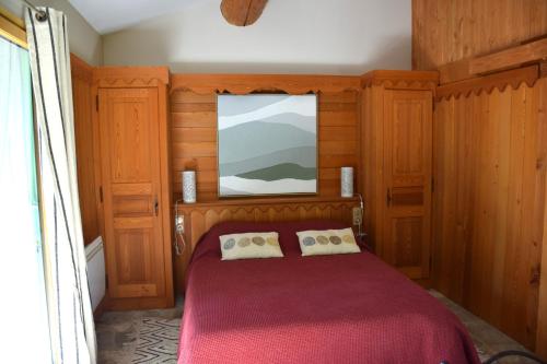 a bedroom with a red bed and a window at Gite de Lise in Blandas