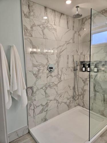 a bathroom with a shower with a glass door at Calm on the Crescent in St. John's