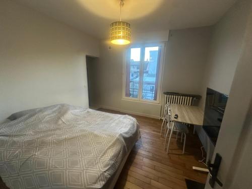 a bedroom with a bed and a desk and a window at Chambre privee dans une maison 2 in Aulnay-sous-Bois