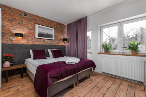 a bedroom with a bed and a brick wall at AURA 77 Żoliborz in Warsaw