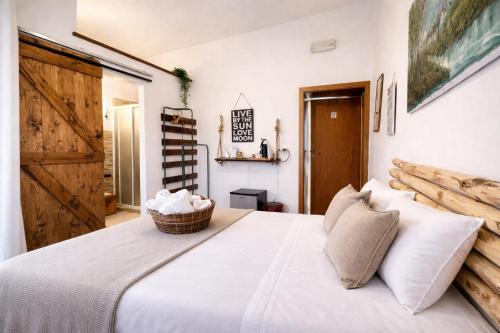 a bedroom with a white bed with a wooden door at Villa Corocael in Castellabate