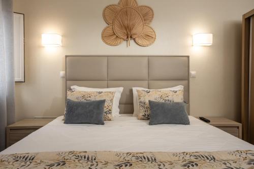 a bedroom with a large bed with two pillows at Rosa dos Ventos in Zambujeira do Mar