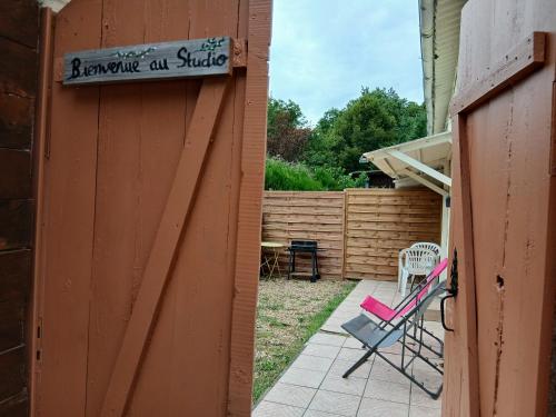 a backyard with a sign on the side of a house at Studio meublé au vert - 3km de Périgueux in Boulazac