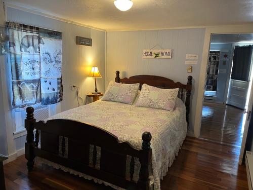 a bedroom with a bed and a lamp on a wooden floor at Cochran Farm House in Bryson City