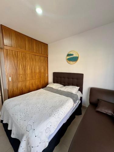 a bedroom with a large bed with a wooden headboard at Fantástico Depa en BLUU con Playa Artificial ! in Mazatlán