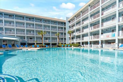 a large swimming pool in front of a large building at Coastal 2BR Condo w Ocean Views & Pool in Hilton Head Island