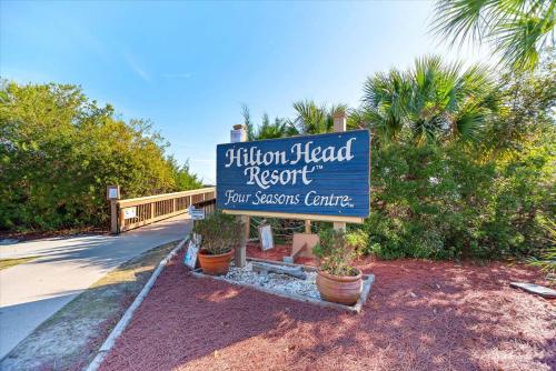 a sign for a visitor head resort with potted plants at Coastal 2BR Condo w Ocean Views & Pool in Hilton Head Island