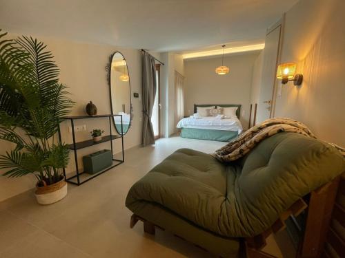 a bedroom with a bed and a green ottoman at Velithea Luxury Suites in Ioannina