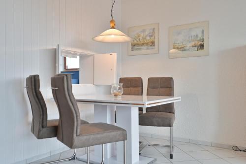 a dining room with a white table and chairs at FeWo Lange - Whg 48 in Kellenhusen
