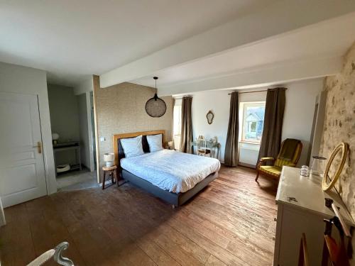 a bedroom with a bed and a table and chairs at LE DOMAINE DE COAT ROGAN, La chambre du Jaudy in Pommerit-Jaudy