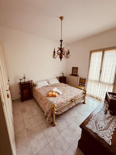 a bedroom with a bed and a chandelier at Novecento Apartment in Forlì
