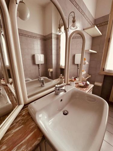 a bathroom with a sink and a mirror at Novecento Apartment in Forlì
