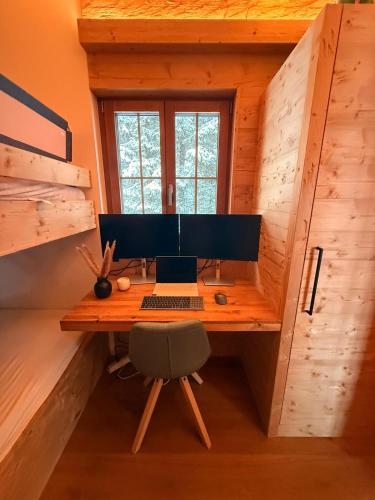 a computer sitting on a desk in a cabin at Chalet Spatz Loft with Sauna Kandersteg Oeschinen Lake in Kandersteg