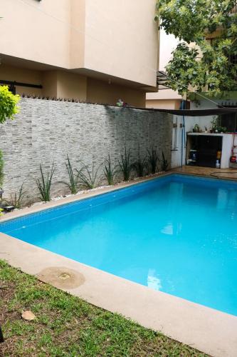 a blue swimming pool in front of a building at Departamentos Perfectamente ubicados con alberca in Ciudad Madero