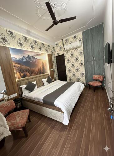 a bedroom with a large bed with a painting on the wall at HOTEL SHREE KANHA in Jaipur