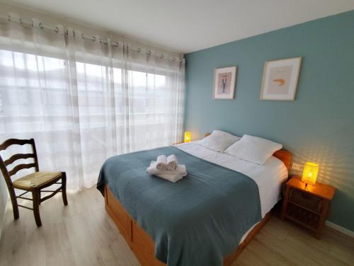 Un dormitorio con una cama con dos toallas encima. en Terre-Mer, en Fort-Mahon-Plage